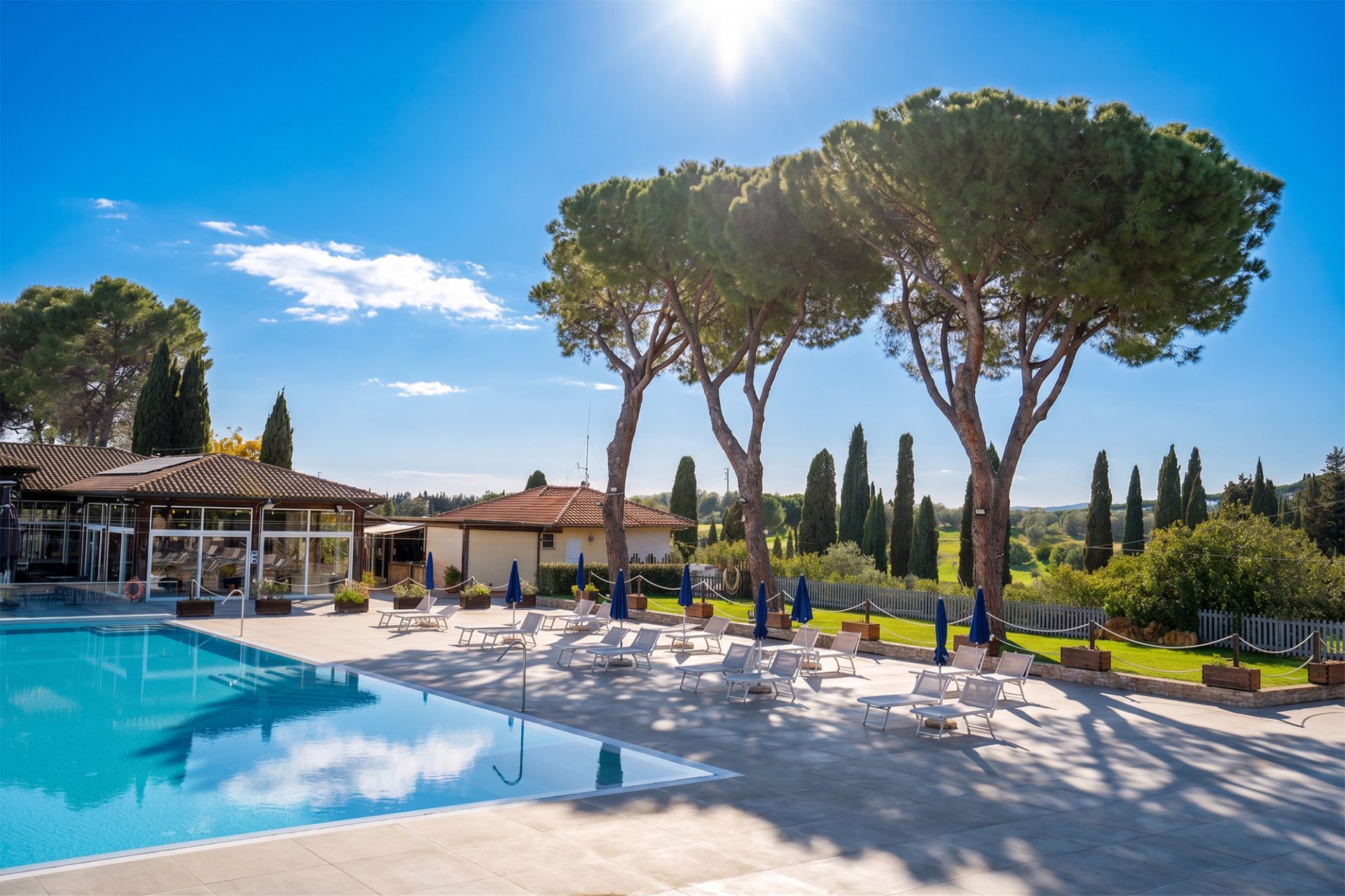 Poollandschaft des Il Pelagone mit Pinien und Blick über die Maremma